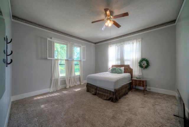 carpeted bedroom featuring a textured ceiling, ceiling fan, and ornamental molding