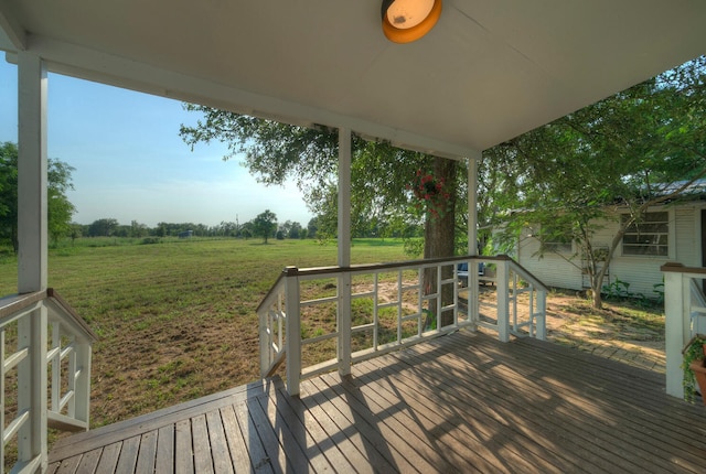 deck featuring a rural view and a yard