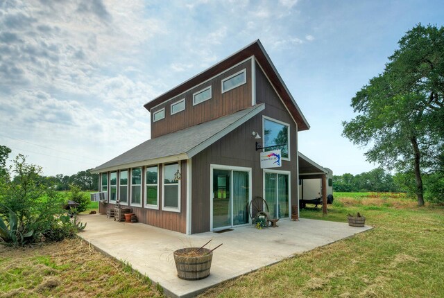 back of property with a yard and a patio area