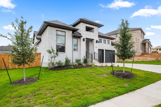 prairie-style home with a front yard and a garage