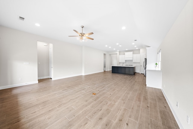 unfurnished living room featuring light wood-type flooring and ceiling fan