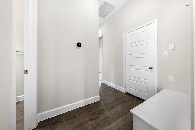 corridor featuring lofted ceiling and dark hardwood / wood-style flooring