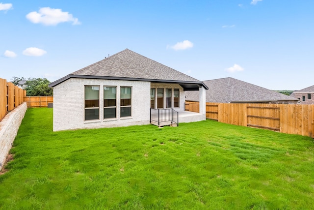 rear view of property featuring a patio area and a lawn