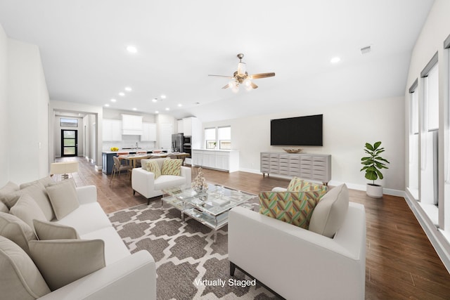 living room featuring ceiling fan, dark hardwood / wood-style flooring, and sink