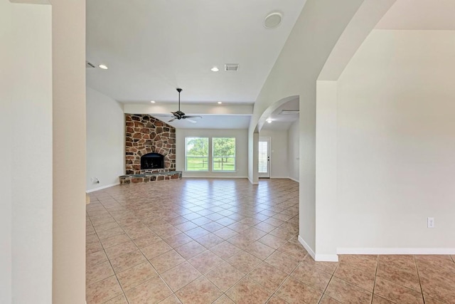 unfurnished living room featuring light tile patterned floors, a fireplace, ceiling fan, and vaulted ceiling