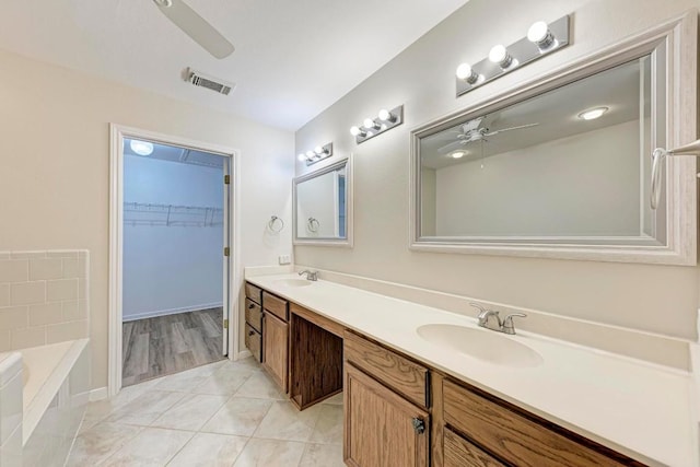 bathroom featuring tile patterned flooring, vanity, a bathing tub, and ceiling fan