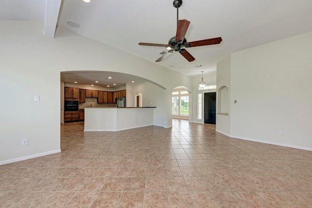 unfurnished living room with ceiling fan, lofted ceiling with beams, and light tile patterned floors