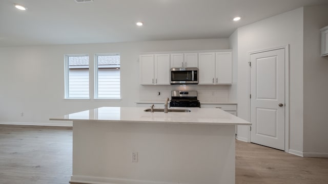 kitchen featuring white cabinetry, a center island with sink, sink, and appliances with stainless steel finishes