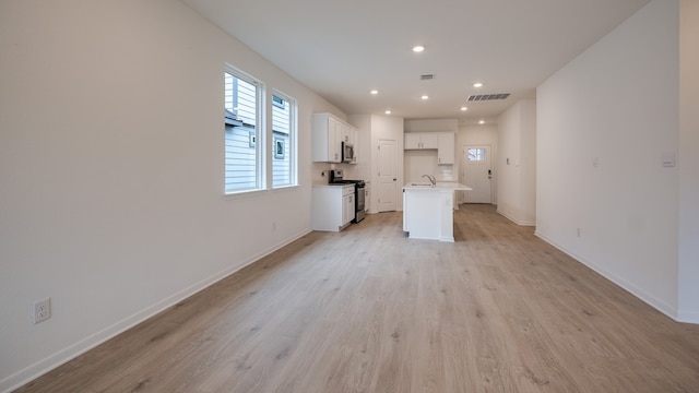 unfurnished living room with light hardwood / wood-style flooring and sink