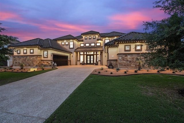 mediterranean / spanish-style home with a yard, french doors, and a garage