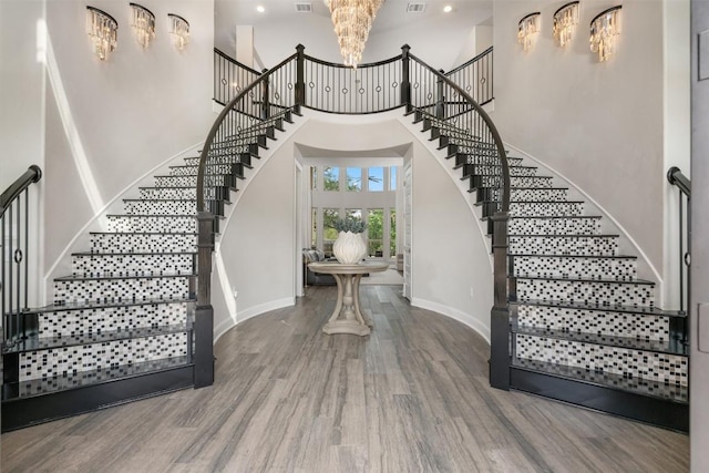 entrance foyer with wood-type flooring and a towering ceiling