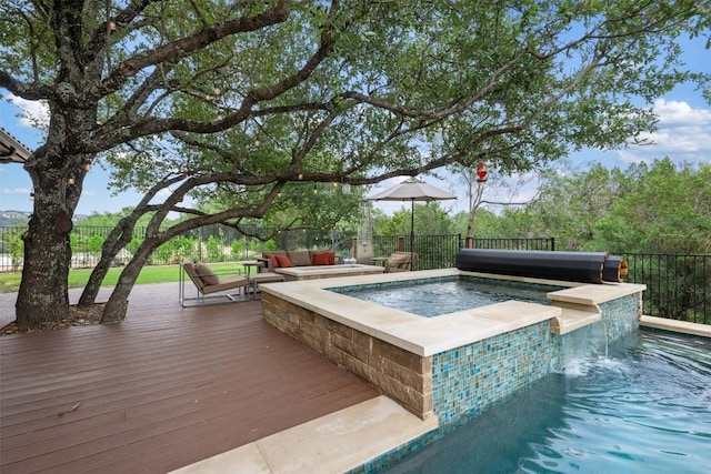 view of pool featuring an in ground hot tub, pool water feature, an outdoor living space, and a deck