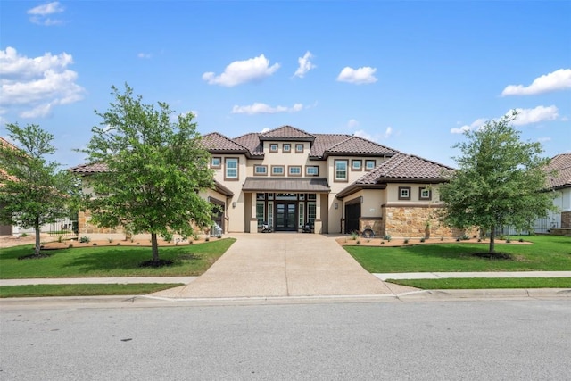 mediterranean / spanish-style home with a front yard and french doors