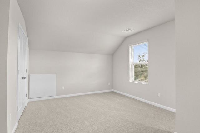 bonus room featuring light carpet and lofted ceiling