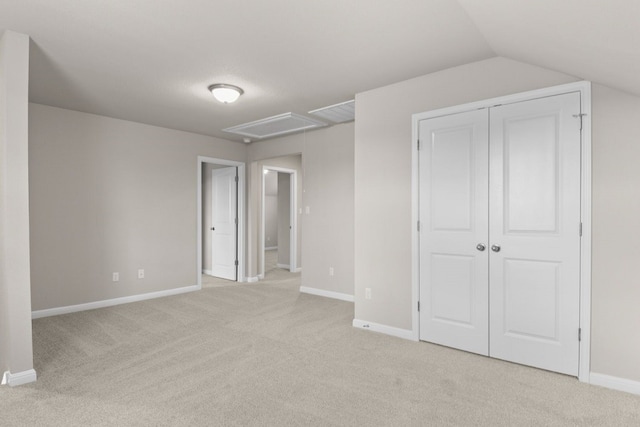 unfurnished bedroom with light carpet, vaulted ceiling, and a closet