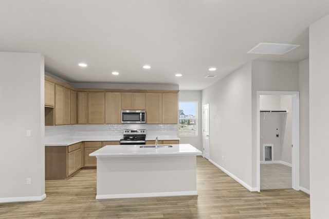 kitchen featuring sink, light wood-type flooring, a kitchen island with sink, and stainless steel appliances