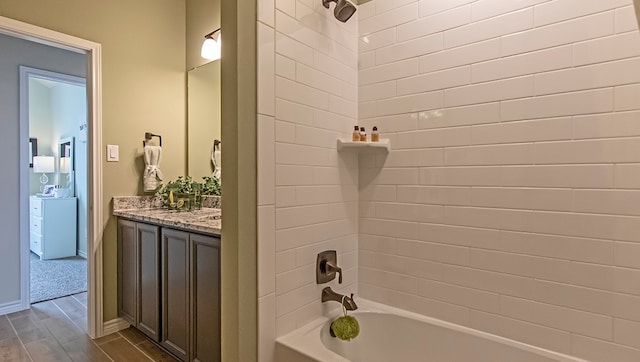 bathroom featuring tiled shower / bath, vanity, and hardwood / wood-style floors