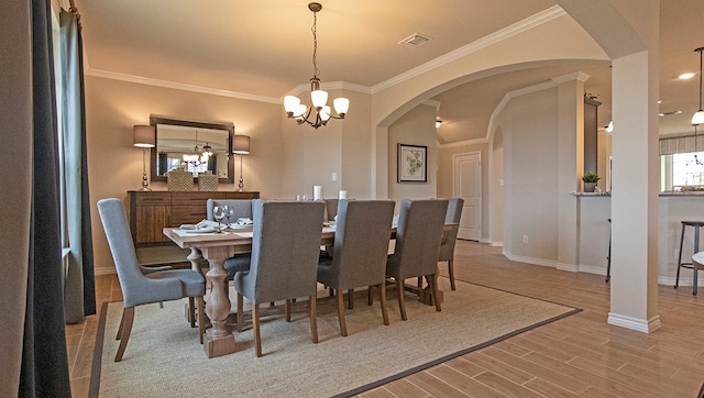 dining room featuring a chandelier, ornamental molding, and wood-type flooring