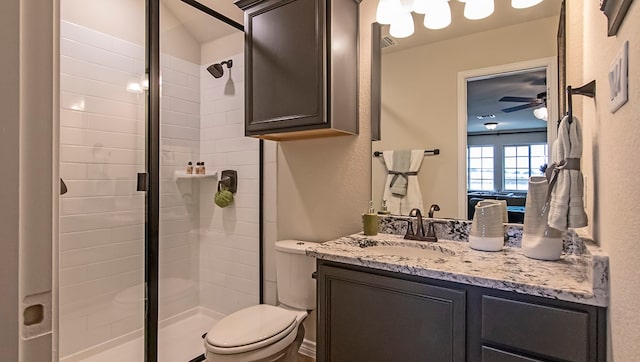 bathroom featuring ceiling fan, a shower with shower door, oversized vanity, and toilet