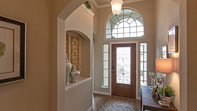 foyer entrance featuring hardwood / wood-style flooring and crown molding