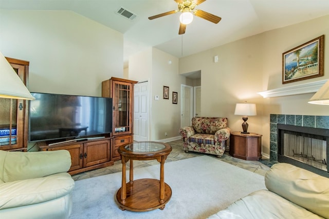 living room with light tile floors, ceiling fan, a fireplace, and lofted ceiling