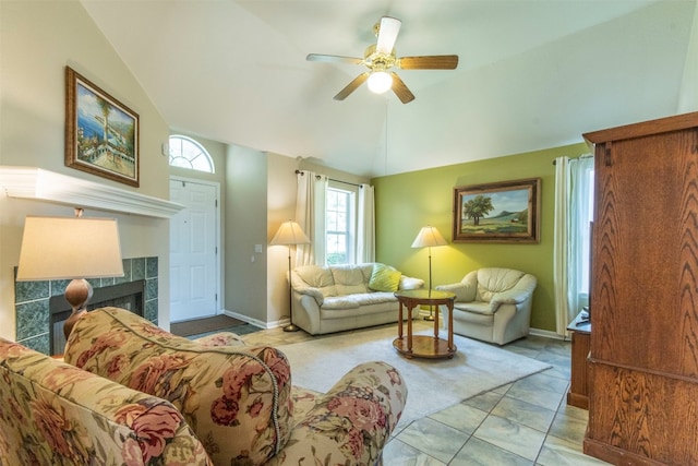 tiled living room featuring ceiling fan, a tile fireplace, and lofted ceiling