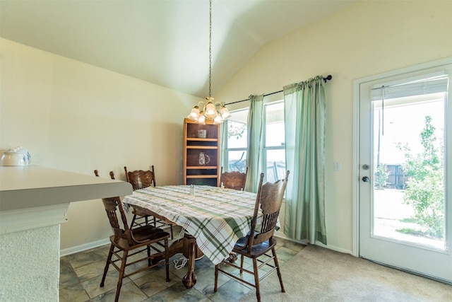 dining space with a notable chandelier, tile flooring, and vaulted ceiling