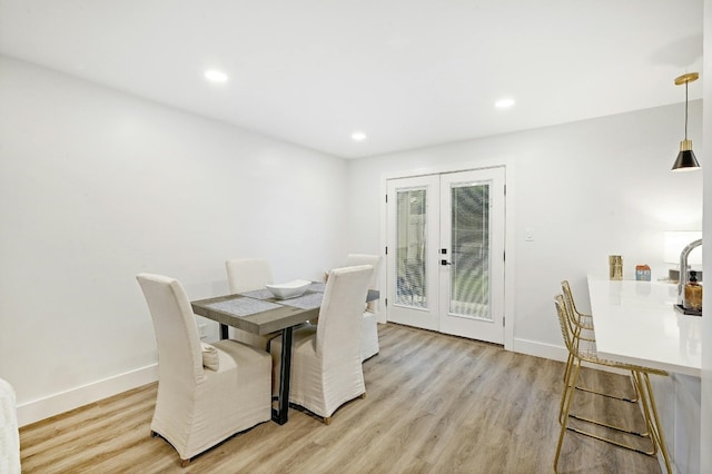 dining area with light hardwood / wood-style flooring and french doors