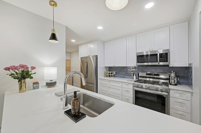 kitchen featuring appliances with stainless steel finishes, white cabinetry, sink, and backsplash