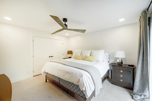 bedroom featuring a closet, ceiling fan, and light colored carpet