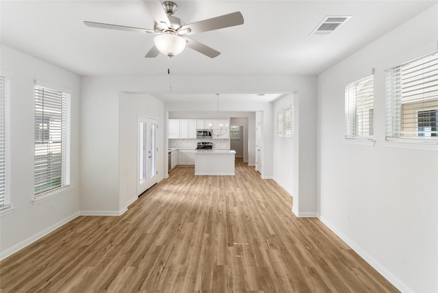 unfurnished living room featuring ceiling fan and light hardwood / wood-style flooring