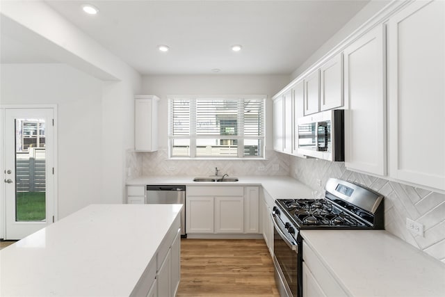 kitchen featuring sink, white cabinetry, stainless steel appliances, and tasteful backsplash