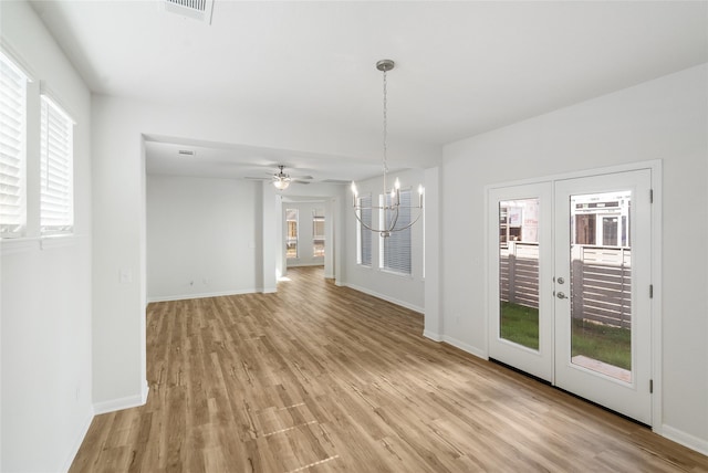 unfurnished living room featuring light wood-type flooring, a wealth of natural light, and french doors