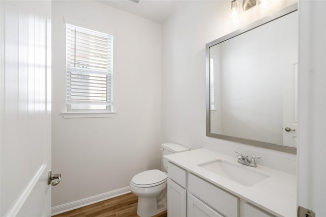 bathroom featuring toilet, hardwood / wood-style floors, and vanity