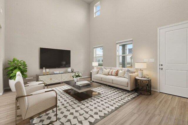 living room featuring a towering ceiling and light hardwood / wood-style flooring