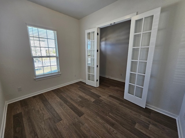 unfurnished room featuring french doors and dark wood-type flooring