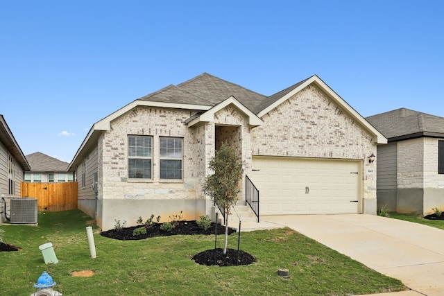 view of front of property with central air condition unit, a garage, and a front yard