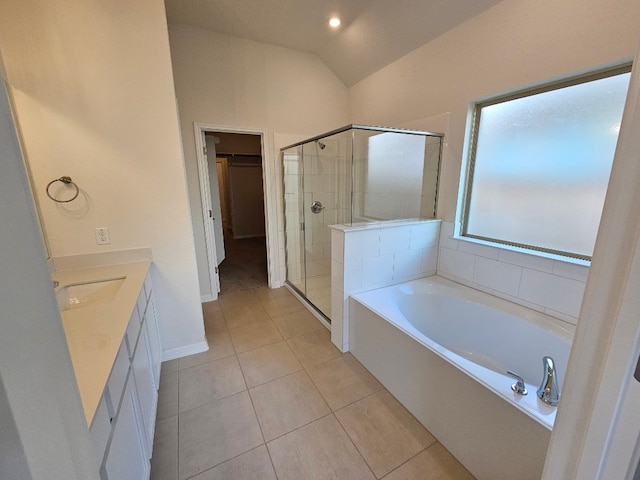 bathroom with vaulted ceiling, vanity, plus walk in shower, and tile patterned floors