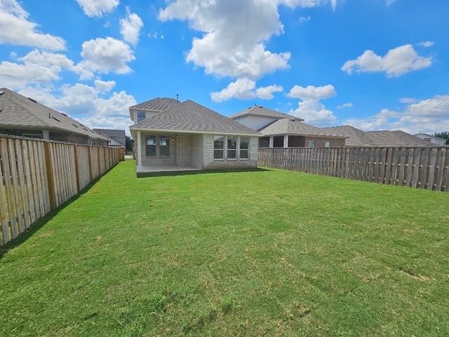 rear view of house featuring a patio area and a yard