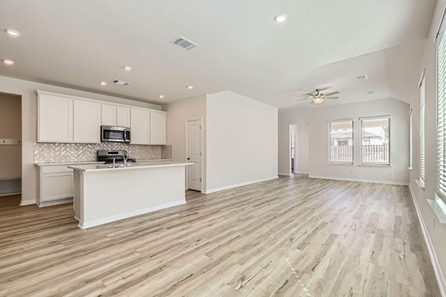 kitchen with visible vents, a ceiling fan, stainless steel appliances, light countertops, and decorative backsplash