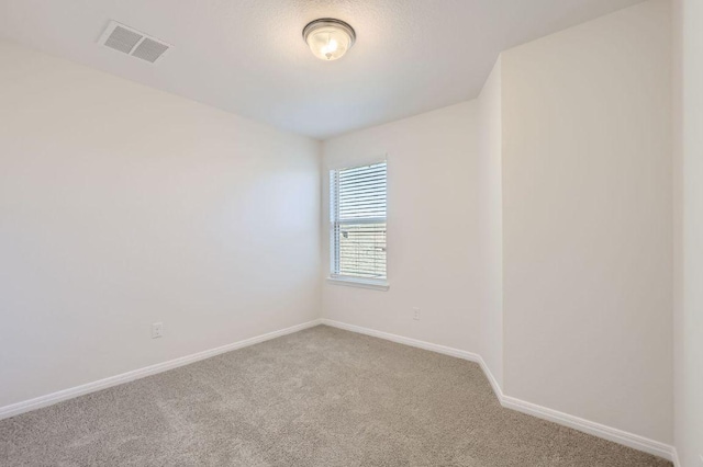 carpeted empty room featuring visible vents and baseboards