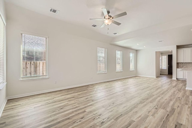 unfurnished living room featuring visible vents, baseboards, and light wood-style floors