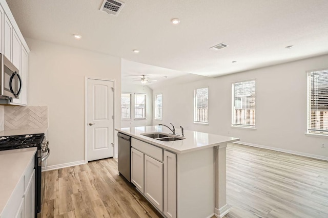 kitchen with light wood finished floors, visible vents, appliances with stainless steel finishes, and a sink