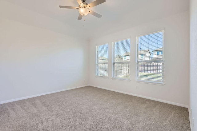 empty room featuring carpet flooring, a ceiling fan, and baseboards