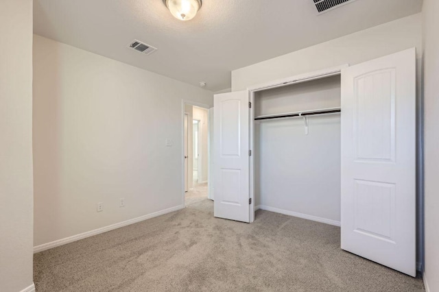 unfurnished bedroom featuring a closet, baseboards, visible vents, and carpet floors