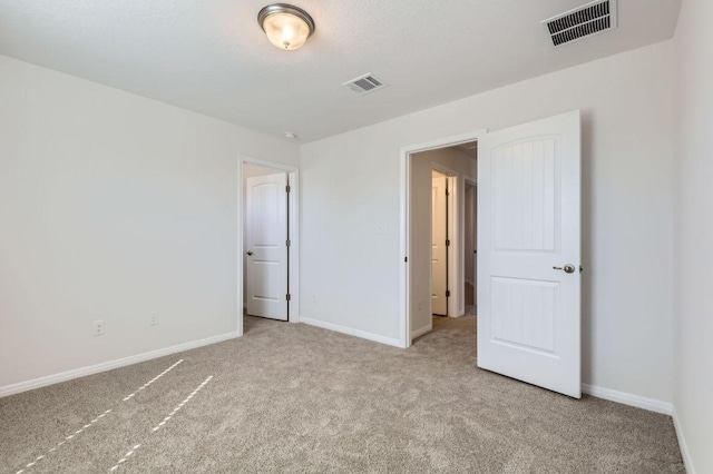 unfurnished bedroom with visible vents, baseboards, and carpet