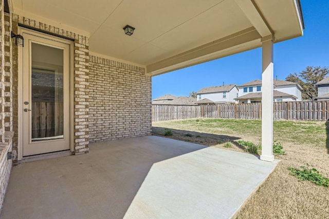 view of patio / terrace with a residential view and fence