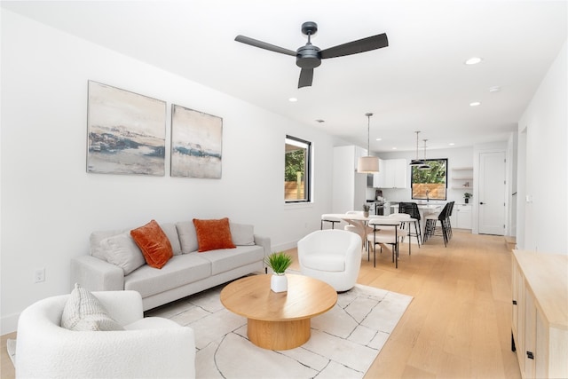 living room featuring light wood-type flooring and ceiling fan