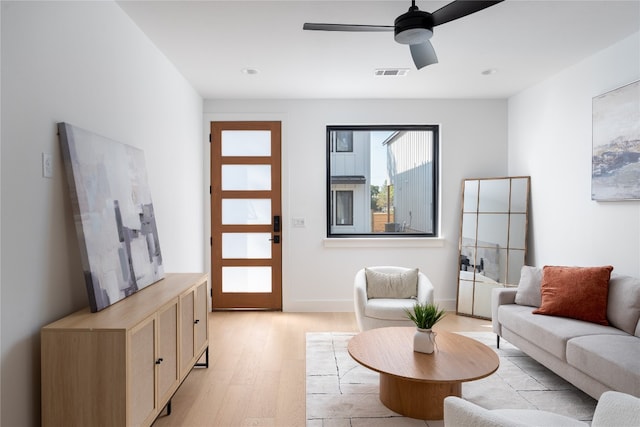 living room with ceiling fan and light hardwood / wood-style flooring