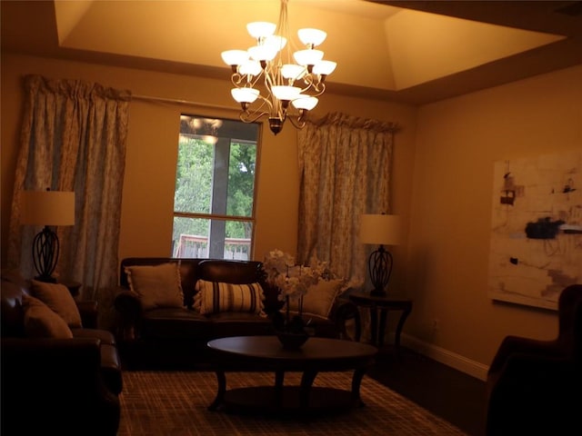 living area featuring a tray ceiling and an inviting chandelier